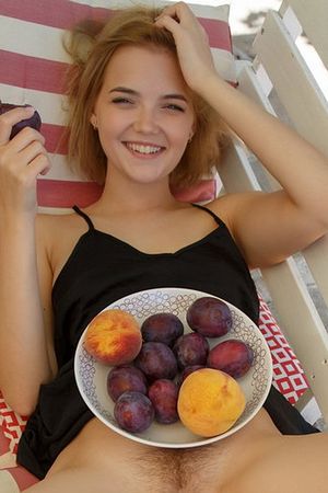 Девушка позирует с блюдом фруктов на волосатом лобке