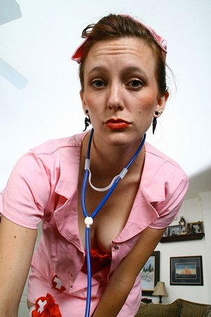 Зрелая медсестра сексуально позирует и теребит пиздень